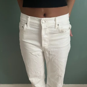 Vita raka jeans från Zara - Säljer ett par vita jeans från Zara i rak modell. Byxorna har normalhög midja. Byxorna har fler knappar så man kan vika ner dom. Använt ca 1 gång och är i mycket bra skick.