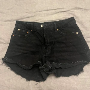 Svarta jeansshorts  - Svarta jeansshorts lågmidjade från gina, perfect jeans med råa, fransiga kanter och klassisk femficksmodell. Shortsen har hög midja och en snygg, lite loose passform. Perfekta för sommaren och enkla att matcha med allt.💕