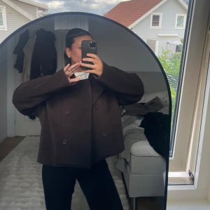 Mörkbrun kappa  - Säljer en oversized mörkbrun kappa med dubbelknäppning och breda slag. Så fin och aldrig använd från Ginatricot och är i storlek L men passa alla storlekar beroende på hur oversized man vill ha den!