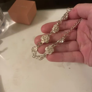 Silverfärgat armband med blommor - Superfint armband i silverfärg med detaljerade blommor som länkar. Perfekt accessoar för att lyfta din outfit med en söt och unik touch. Lätt att matcha med andra smycken och passar dig som gillar blommiga detaljer.