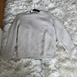 Beige stickad tröja från Zara - Mysig beige stickad tröja från Zara med rund halsringning och ribbade muddar vid ärmslut och nederkant. Perfekt för lager-på-lager och enkel att matcha med jeans eller kjol. Stilren och enkel design som funkar året runt.