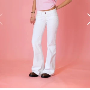Vita bootcut jeans med låg midja - Snygga vita jeans med bootcut och låg midja. Byxorna har klassisk femficksdesign och är tillverkade i ett stretchigt jeanstyg som sitter skönt. Perfekta för dig som vill ha en clean och fräsch look med lite 00-talsvibe.