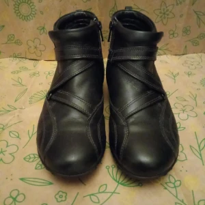 Svarta Ecco skinnboots med dragkedja - Svarta boots i skinn med grov sula och dragkedja på insidan. Snygga detaljer med korsande remmar och rund tå. Perfekta för höst och vinter när du vill ha både stil och funktion. Fodrade för extra värme och komfort.                                                                          Kan skickas med extra pris via post.