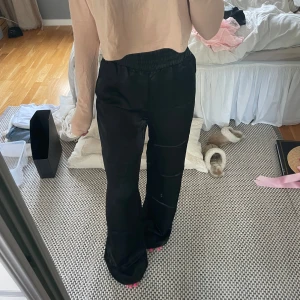 Svarta satinbyxor - Säljer ett par svarta ”satin”byxor med risår i midjan och låtsasfickor bak. Helt nya med lapp kvar. Säljer då de är för långa.