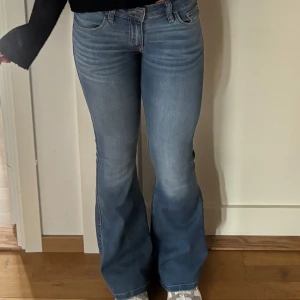 Blå low-rise flare jeans Hollister - Säljer ett par snygga blå jeans från Hollister med låg midja och utsvängda ben. Modellen är Low-Rise Flare. Snygga detaljer på bakfickorna. Jag är 165 cm lång. Använda en gång! Pris går att diskutera!!❣️