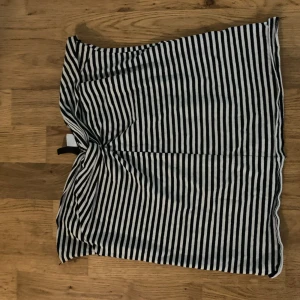 Randig tub top från Divided - Säljer en svartvit randig tub top från Divided. Tub toppen har raka linjer och är tillverkad i mjuk bomull, perfekt för en chill och stilren look. Passformen är normal och tyget är lätt och bekvämt. Enkelt plagg som funkar till många outfits.