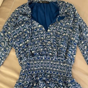 Blåmönstrad klänning från Zara - Snygg blå, klänning från Zara med lång ärm. Jag har använt klänningen 3 gånger och den är som ny. Passar perfekt till sommardagar.