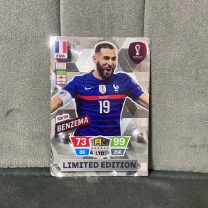 Karim Benzema Limited Edition - FIFA World Cup Qatar 2022 - Snygg limited edition-samlarbild på Karim Benzema från FIFA World Cup Qatar 2022! Perfekt för dig som älskar fotboll, samlar på Panini-kort eller vill boosta din Adrenalyn XL-kollektion. Kortet har cool design och höga stats – ett måste för fans!