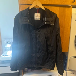 Svart vindjacka från Moncler - Moncler jacka i svart. Mycket bra skick och endast få tecken på användning. Nypris ca. 9000 kr. Storlek 2, motsvarar Small men funkar utmärkt även för dig som bär Medium. Riktigt skön och stilren jacka, perfekt till hösten. Hör av er vid prisförslag och frågor!