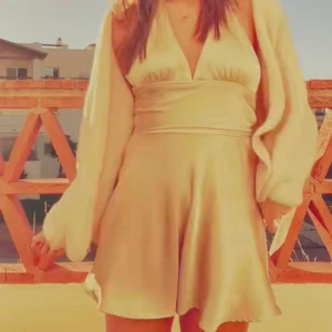 Champagnefärgad omlottklänning med lång ärm - Säljer en champagnefärgad kortklänning med omlott och v-ringning. Klänningen har långa, vida ärmar och markerad midja. Perfekt för dig som gillar en feminin och trendig stil.