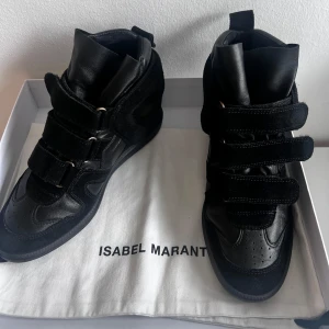 Svarta sneakers från Isabel Marant - Snygga svarta sneakers från Isabel Marant i en kombination av skinn och mocka. Skorna har en rund tå och flera kardborreband för en cool look, använd bara vid ett kort stund, testade hemma ,liten i storleken 39,(38,5)
