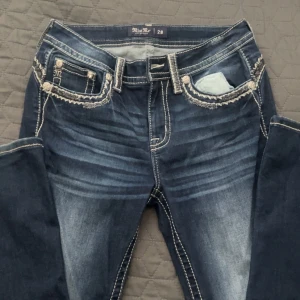 Mörkblå jeansbyxor från Miss Me - Säljer mina mörkblåa bootcut miss me jeans pga att det e fel storlek helt oanvända utan defekter perfekt för dig som gillar lite extra på jeansen vid snabb köp kan pris diskuteras💗