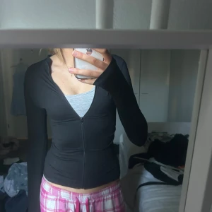 lululemon liknade Svart tight zip-hoodie - Svart tight hoodie med dragkedja framtill och långa ärmar. Snygg och enkel modell som passar till mycket. Perfekt för dig som gillar en figurnära passform.