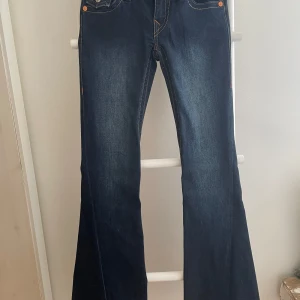 Mörkblå bootcut jeans från True Religion - Säljer ett par mörkblå jeans från True Religion med bootcut passform (low waist).  Modell joey. Byxorna är oanvända har endast testat dom.