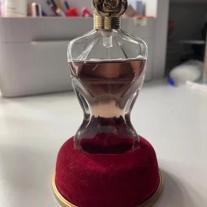 Jean Paul Gaultier La Belle Eau de Parfum 30ml - Säljer en ikonisk parfym från Jean Paul Gaultier, La Belle Eau de Parfum. Flaskan är formad som en kvinnokropp i genomskinligt glas med rosaröd vätska och har ett elegant guldfärgat lock. Kommer med en lyxig röd sammetsbas. Knäppt använd!! originalpris 800:-