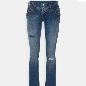 Blå bootcut jeans med slitningar från LTB - Säljer ett par blå bootcut jeans från LTB med slitningar på benen och snygga detaljer på bakfickorna. Jeansen har låg midja, klassisk femficksdesign och stängs med dragkedja och dubbla knappar. Jag har sytt ut men till lite mer bootcut, midja 28 längd 36 Jätte bra skick 