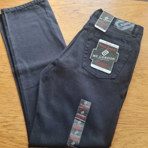 Jeansbyxor från MC Gordon strl 34x34 (herr) - Snygga svarta jeansbyxor från MC Gordon i modellen Black Denim. Klassisk femficksdesign med raka ben och normal passform. 100% bomull. Storlek 34x34. Kan hämtas i Vallentuna.