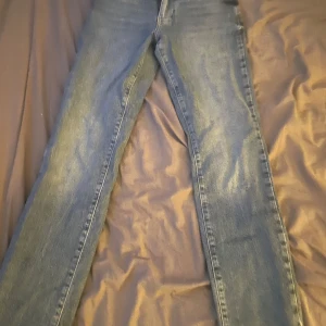 Blå raka jeans med straight fit - Säljer ett par klassiska blå jeans som har blivit för små i midjan, storlek 25 i midjan och längd 32. Pris går att diskutera, osäker på vart dom är ifrån men står på jeansen (denim never)🥰