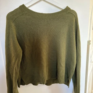 Olivgrön stickad tröja från H&M Divided - Säljer en olivgrön stickad tröja från H&M Divided i storlek M. Tröjan har en avslappnad passform, rund halsringning och långa ärmar. Perfekt för lager-på-lager och enkel att matcha med jeans eller kjol. Lite kortare i modellen.