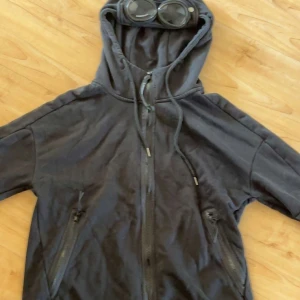 Svart hoodie CP Company - Säljer en cp company hoodie. Den är i fint skick bara tvättad ett fåtal gånger. Storlek L men passar M