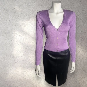 Lila stickad kofta med v-ringning - Snygg lila stickad kofta med v-ringning och knappar framtill. Perfekt för att lägga till en färgklick i garderoben. Långärmad och figurnära passform som framhäver silhuetten. #mango #troja