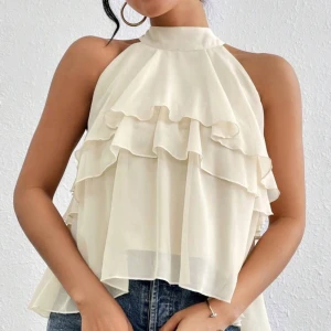 Vit ärmlös blus med volanger - Säljer en fin ljus gul blus med flera lager av volanger framtill. Aldrig använd❤️