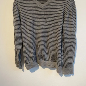 Grå svart randig stickad tröja - Fin stilren tröja som är använda väldigt fåtal gånger alltså väldigt bra skick, de är bra material. Varan kommer skickas inom 24 timmar från att du köpt plagget📦