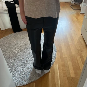 Svarta skinnliknande byxor - Snygga svarta byxor i skinnimitation från Mango. Jag har vikt upp/öppnat upp kanten där nere som var ”fastlimmad” innan för att få 2-3 extra cm på längden så det är det som syns på sista bilden på insidan, men det är inget som syns annars och det skulle gå att sy tillbaka kanten om man skulle vilja det. Dessa byxor passar för lite längre personer då de är långa i benen!
