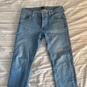 Blå jeans från Lee - Säljer ett par klassiska blå jeans från Lee med dragkedja. Passform Darren Zip Fly. Knappt använda som bara legat i garderoben. Skriv för mer bilder eller frågor.