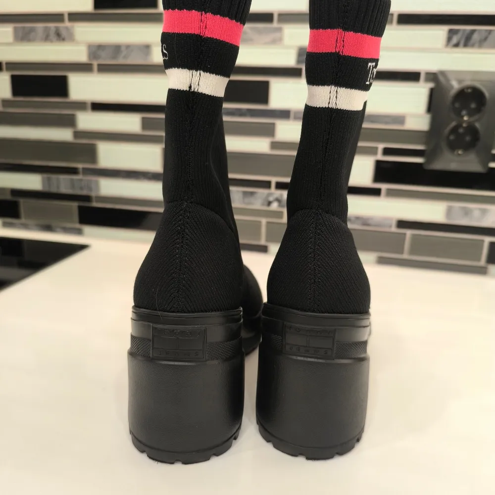 Snygga svarta boots från Tommy Jeans med en ribbad överdel och märkets logga i rött och vitt. Skorna har en robust klack och en bekväm passform. Perfekta för att ge din outfit en stilren touch. använda flera gånger, nästan nya.. Kengät.