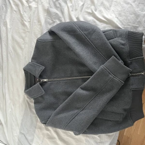 Overshirt jacka - Snygg grå overshit med dragkedja och ribbade muddar. Perfekt för en stilren look. Jackan har en klassisk krage och långa ärmar. ALDRIG ANVÄND KÖPT FÖR 699:-