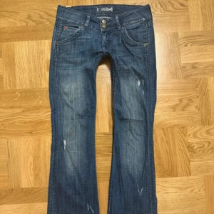  lågmidjade jeans från Hudson - Snygga blå jeansbyxor från Hudson med väldigt låg midja och bootcut-stil. Byxorna har en klassisk femficksdesign och slitna detaljer för en trendig look. Perfekta för en avslappnad stil. passar allt! storlek 34/36, super gulliga 