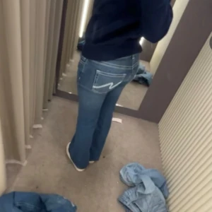 Blå jeans med broderade bakfickor - Snygga jeans från Nelly med broderade fickor, fint skick och storlek 34