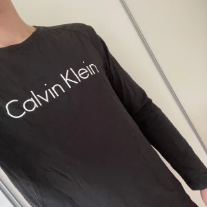Svart långärmad tröja från Calvin Klein - Säljer en svart långärmad tröja från Calvin Klein. Det är en pyjamaströja men den funkar lika bra att använda som en vanlig långärmad tshirt. Kan sänka pris vid snabb affär. Nästan aldrig använt.
