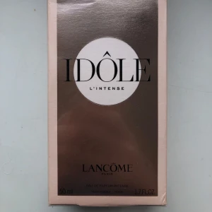 Idôle L'Intense Eau de Parfum från Lancôme - Upptäck Idôle L'Intense från Lancôme, en elegant och kraftfull doft i en stilren förpackning. Flaskan innehåller 50 ml av denna intensiva parfym, perfekt för den som vill göra ett starkt intryck. En lyxig doftupplevelse från ett välkänt franskt märke.