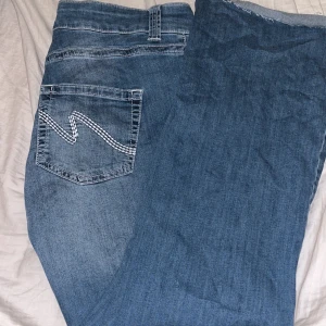 Blå jeans med broderad bakficka - Snygga blå jeans från Nelly med broderade detaljer på bakfickorna. de är klippta nertill för att passa mig. Jag är en och 161 cm och de passar perfekt de är boot Cat och det är stretchiga jeans. De är använda ett fåtal gånger