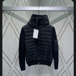 Svart Monclair cardigan - Snygg svart cardigan, med huva och dragkedja framtill. Det är en moncler jacka som är använd i ett väldigt bra skick. Det finns två stycken en i S och en i storlek M. 