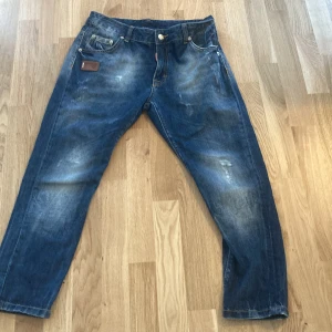 Blå jeans från Dsquared2 - Snygga blå jeans från Dsquared2 med en cool tvättad look. De har en klassisk femficksdesign och en läderpatch med logotypen på baksidan. Perfekta för en avslappnad stil.