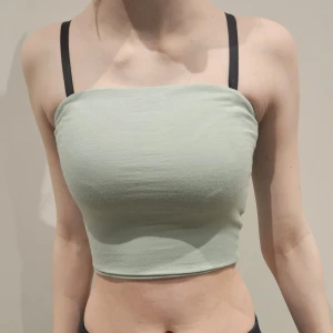 Croppad tubtopp - Ljusgrön croppad tubtopp i mjukt material. Enkel och stilren design utan mönster, perfekt för varma dagar eller som lager under andra plagg. Sanna färgen är något mer grönblå men i princip samma som på bild.