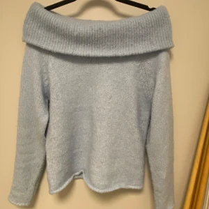 Ljusblå offshoulder stickad tröja från Gina Tricot - Superfin ljusblå stickad tröja från Gina Tricot med bred offshoulder-krage. Mjuk och mysig, perfekt för kyligare dagar. Säljer då den inte kommer till användning längre. Passar snyggt till både jeans och kjol!