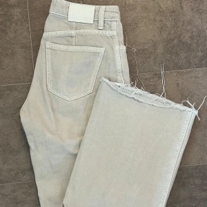 Beige vida jeans med råa kanter - Säljer ett par beige jeans med hög midja och vida ben. Säljer då de är för små för mig.