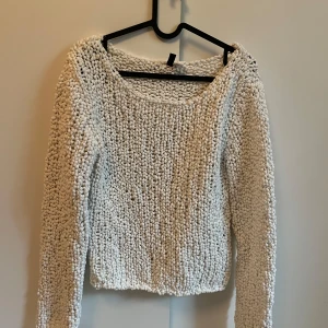 Vit stickad tröja - Mysig vit stickad tröja med grov struktur och lång ärm. Perfekt för kyligare dagar och enkel att matcha med olika outfits. Tröjan har en något lös passform och rund halsringning.