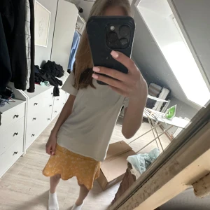 Gul blommig kjol - Säljer en söt gul kjol med vitt blommönster. Kjolen har en kort längd och en lätt utsvängd form som ger en avslappnad och somrig känsla. Perfekt för dig som vill ha en färgglad och trendig look. Pris kan diskuteras💞