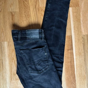 Svarta replay anbass - Säljer ett par svarta Replay Anbass jeans med klassisk femficksdesign och diskreta sömmar. Byxorna har slim passform och är tillverkade i stretchigt material för extra komfort. Perfekta för dig som gillar stilrena och snygga jeans. Storlek 31/32. Skick 8/10. Fråga om du har funderingar😃
