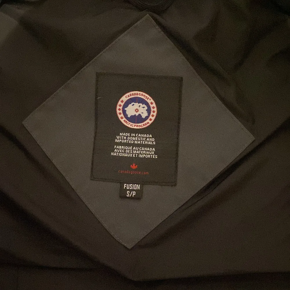Säljer en grå dunväst från Canada Goose med klassisk logotyp på bröstet och knappar framtill. Västen har två stora fickor och är perfekt för lager-på-lager. Stilsäker och varm för kyliga dagar byte kan tas imot hör av sig vid frågor eller intresse!. Takit.