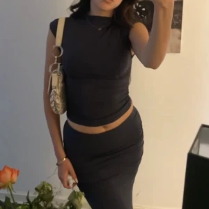 Mörkblå tight set med hög hals - Säljer en mörkblå tight set med hög hals och ärmlös design.  har en kroppsnära passform och slutar strax under knäet. Perfekt för dig som gillar en stilren och enkel look.