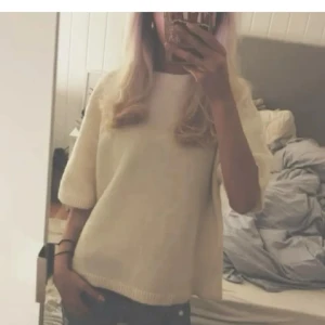 Vit stickad tröja med kort ärm - Säljer en enkel och stilren vit stickad tröja med korta ärmar. Tröjan har en avslappnad passform och är perfekt att matcha med jeans eller kjol. Supermjuk och skön att ha på sig! Från gina i storlek L men skulle säga att den passar S-L