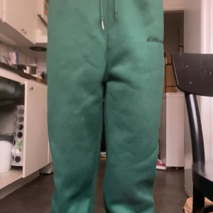 Gröna mjukisbyxor från SHEIN - Mörkgröna mjukisbyxor från SHEIN med dragsko i midjan. Byxorna är tillverkade i mjuk polyesterblandning, har en avslappnad passform och är ganska varma. Perfekta för chill dagar eller när du vill vara bekväm.