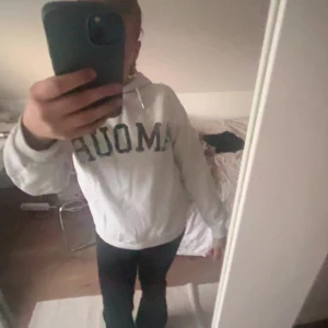 Vit hoodie med tryck från Amour (Gina young) - Grå vit hoddie från Gina young med tryck av stjärna på baksidan och text av amour på framsidan 