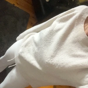 Vit/beige stickad tröja - Säljer en enkel och stilren vit/beige stickad tröja med rund halsringning och långa ärmar. Tröjan har ribbade muddar vid ärmslut och nederkant, perfekt för en clean och avslappnad look.